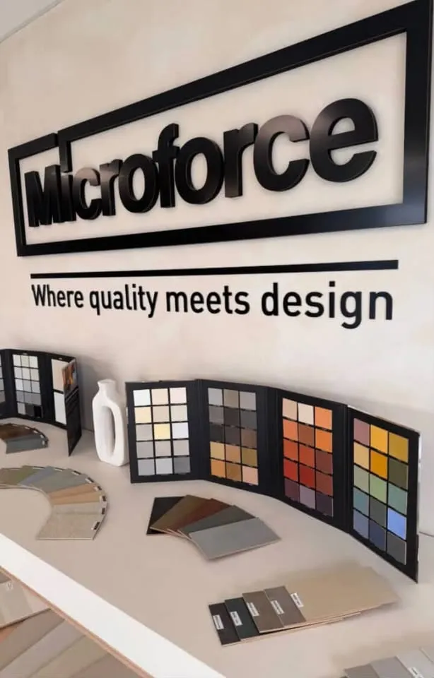 Microforce-showroomin seinä, jolla on sävykarttoja ja mallipaloja koko väriskaalasta.